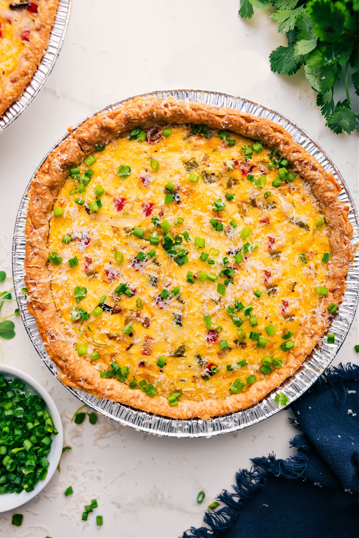 Veggie Quiche Recipe fresh out of the oven with fresh green onions chopped up on top.