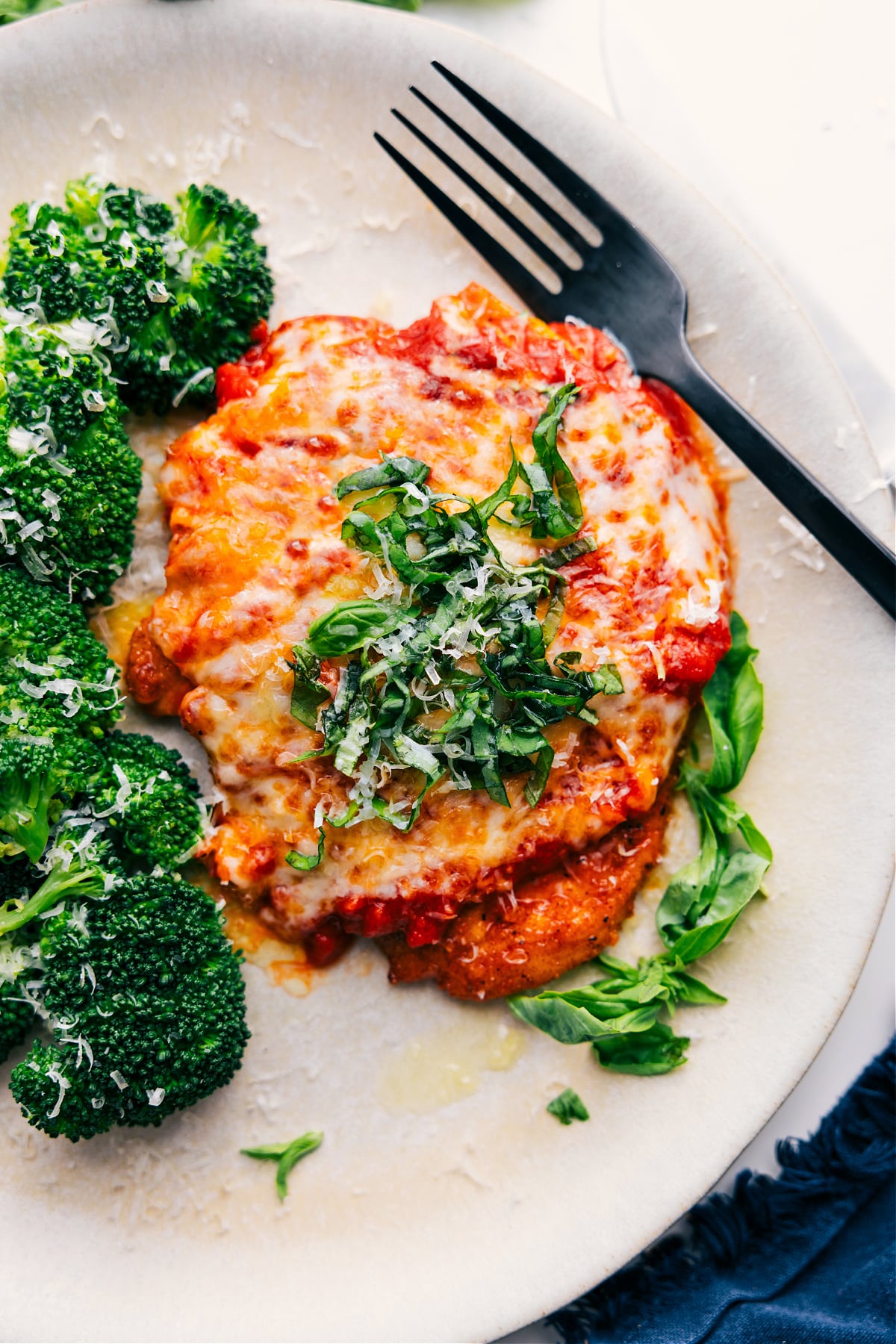 Parmesan Chicken Recipe with fresh Parmesan and basil on top, ready to be enjoyed.
