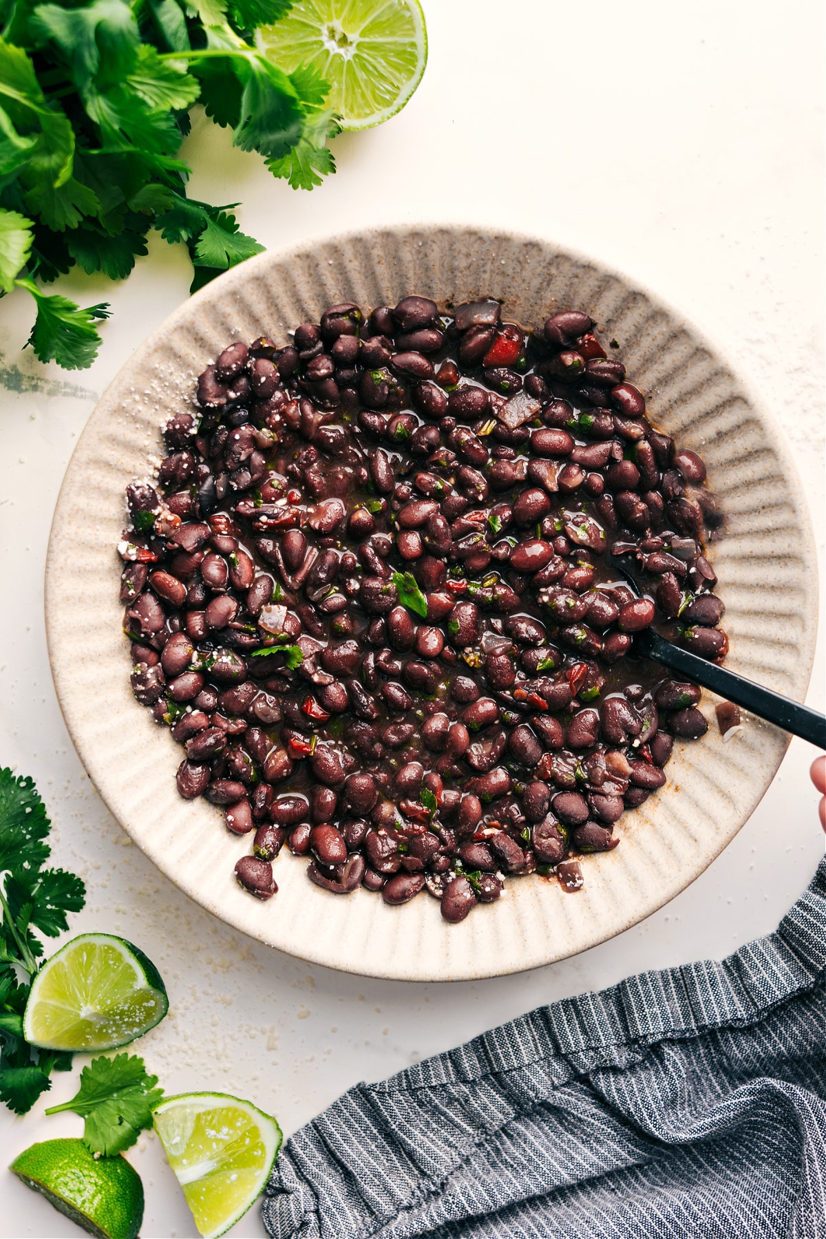 Black beans recipe in a bowl with a spoonful and fresh cilantro on top.