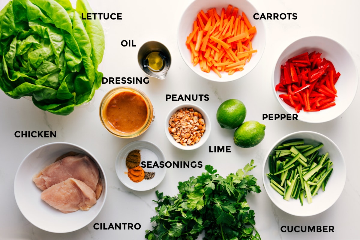 Ingredients In Chicken Lettuce Wraps All the ingredients in this recipe prepped out for easy assembly including the lettuce, chicken, dressing, oil, seasonings, peanuts, carrots, pepper, cucumber, cilantro, and limes.