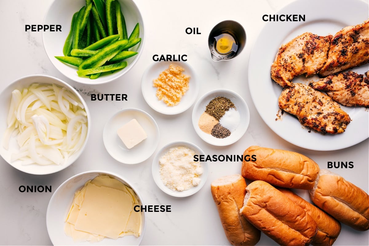 Ingredients In Chicken Philly Cheesesteak Recipe All the ingredients in this recipe prepped out for easy assembly including the onions, cheese, peppers, butter, seasonings, garlic, oil, buns, and chicken.