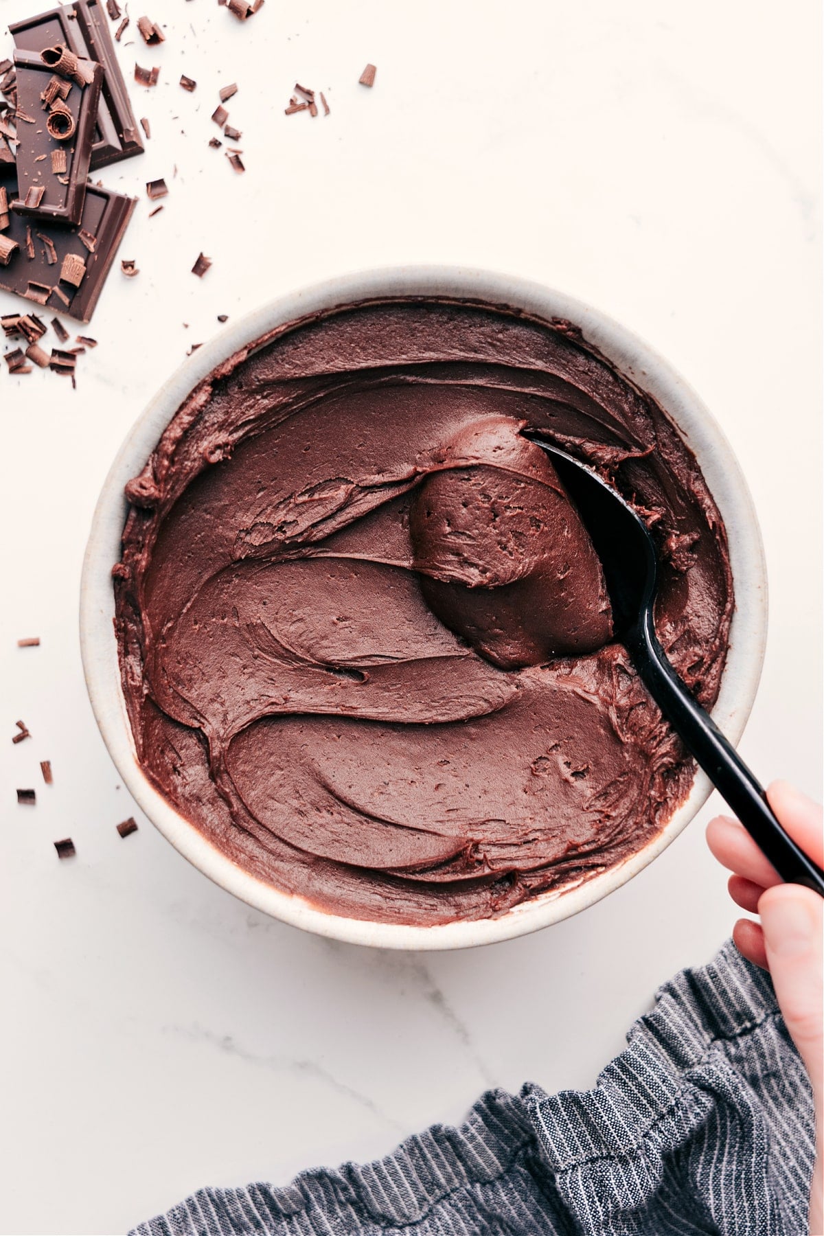 Chocolate Buttercream Frosting Recipe in a bowl with a spoonful coming out.
