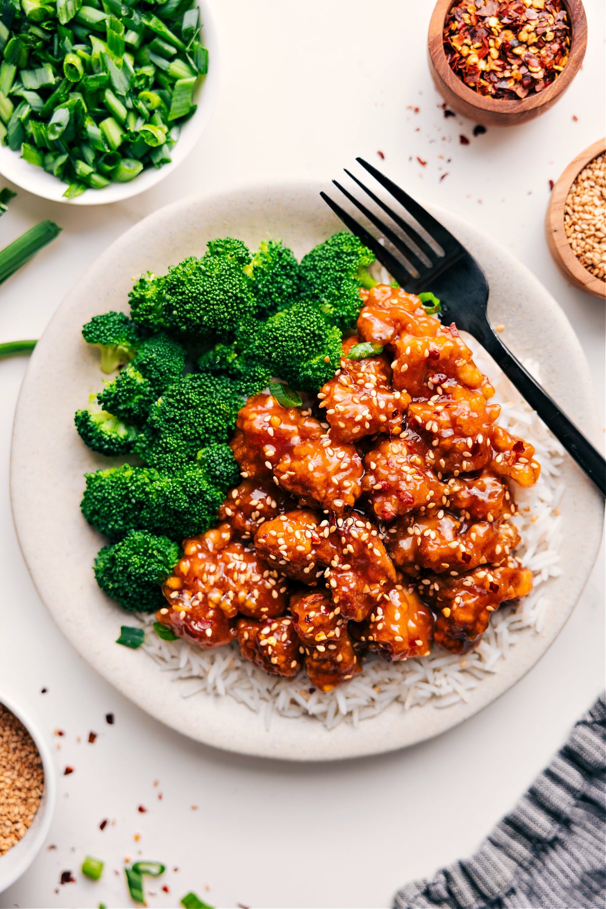 Easy, Saucy, And Delicious Panda Express Orange Chicken Recipe Panda Express Orange Chicken Recipe on a bed of rice and broccoli on the side.
