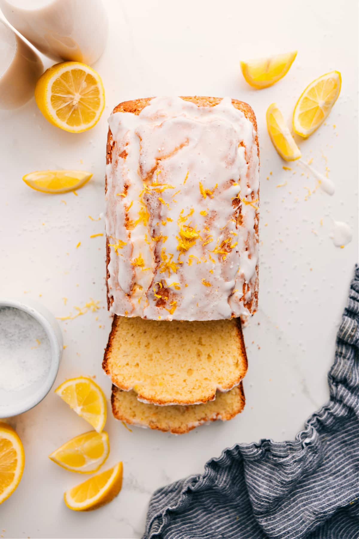Lemon bread recipe with sliced loaf, glossy lemon glaze, and fresh lemon zest on top.