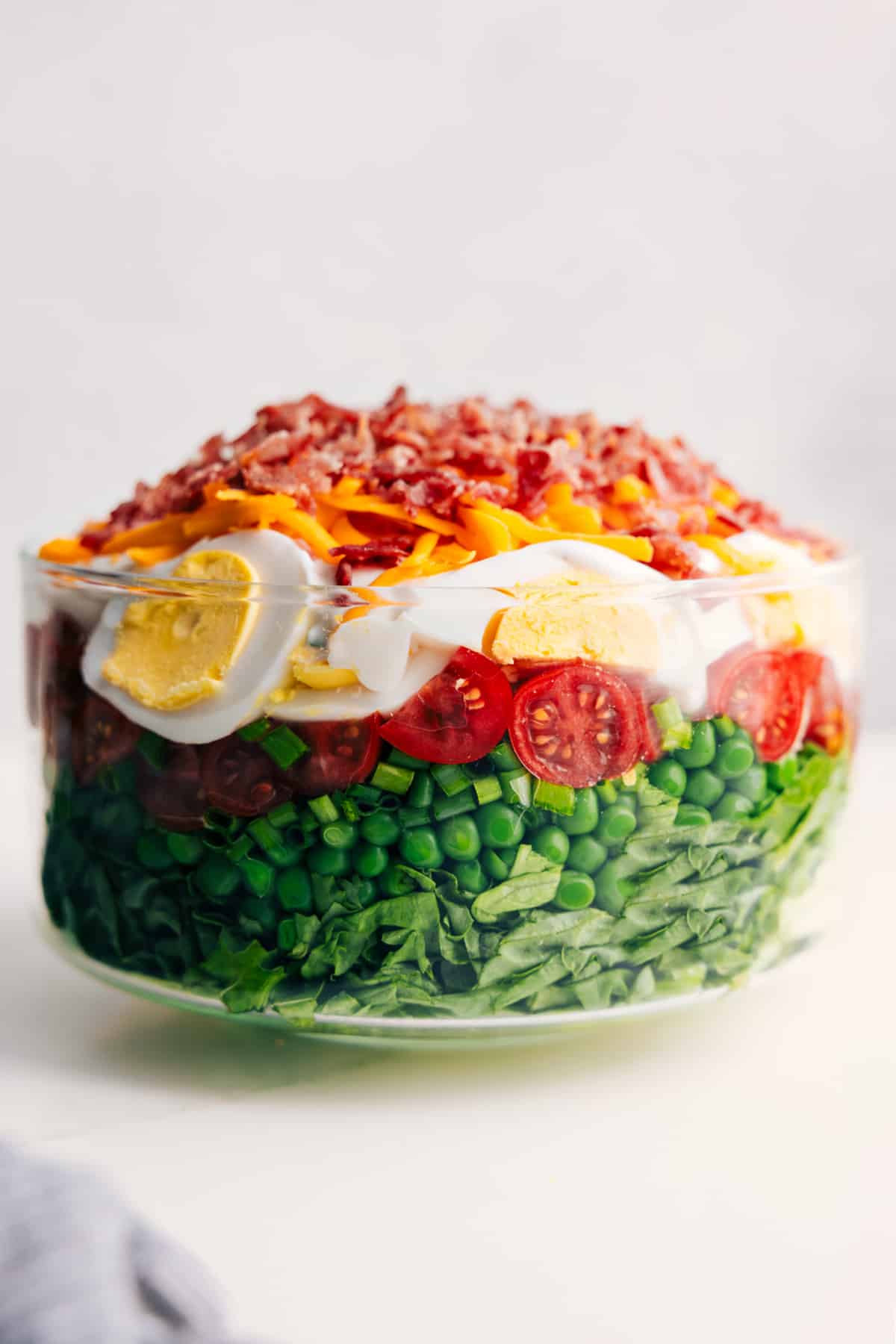 7 Layer Salad in a glass bowl showing all seven colorful layers stacked and visible.