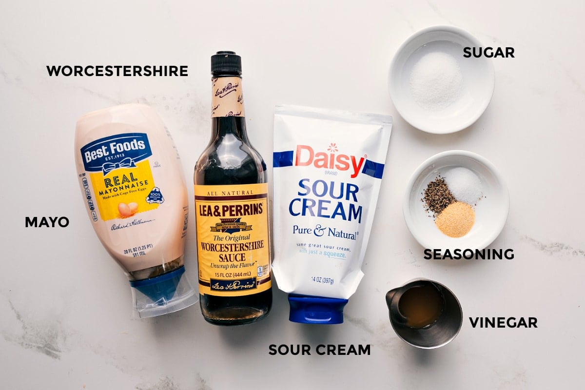Dressing Ingredients For This 7 Layer Salad 7 layer salad dressing ingredients set out for easy assembly including mayo, Worcestershire sauce, sour cream, vinegar, seasoning, and sugar.
