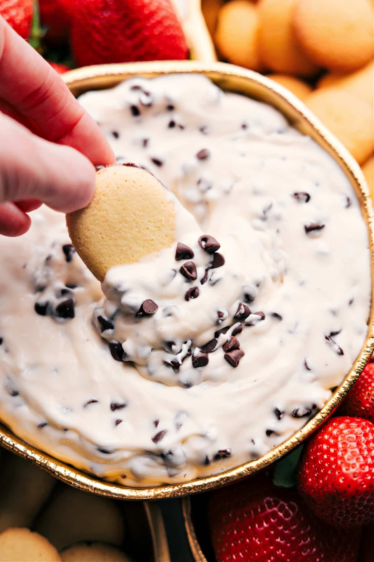 Indulgent And No-Bake Chocolate Chip Dip Chocolate chip dip with a cookie dipping in and extra chocolate chips on top.