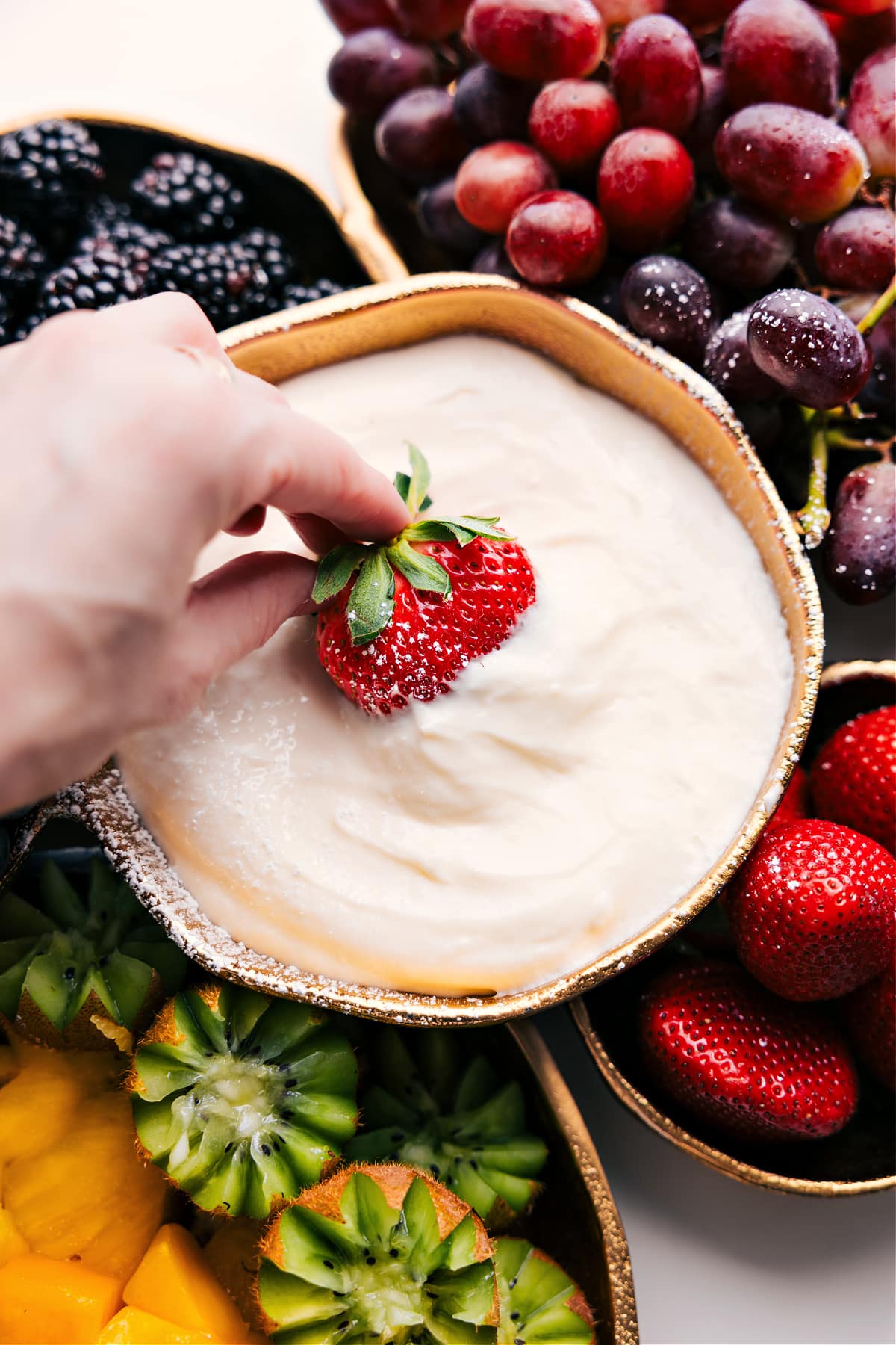Simple, No-Bake Cream Cheese Fruit Dip Recipe Cream Cheese Fruit Dip Recipe with a strawberry being dipped in.