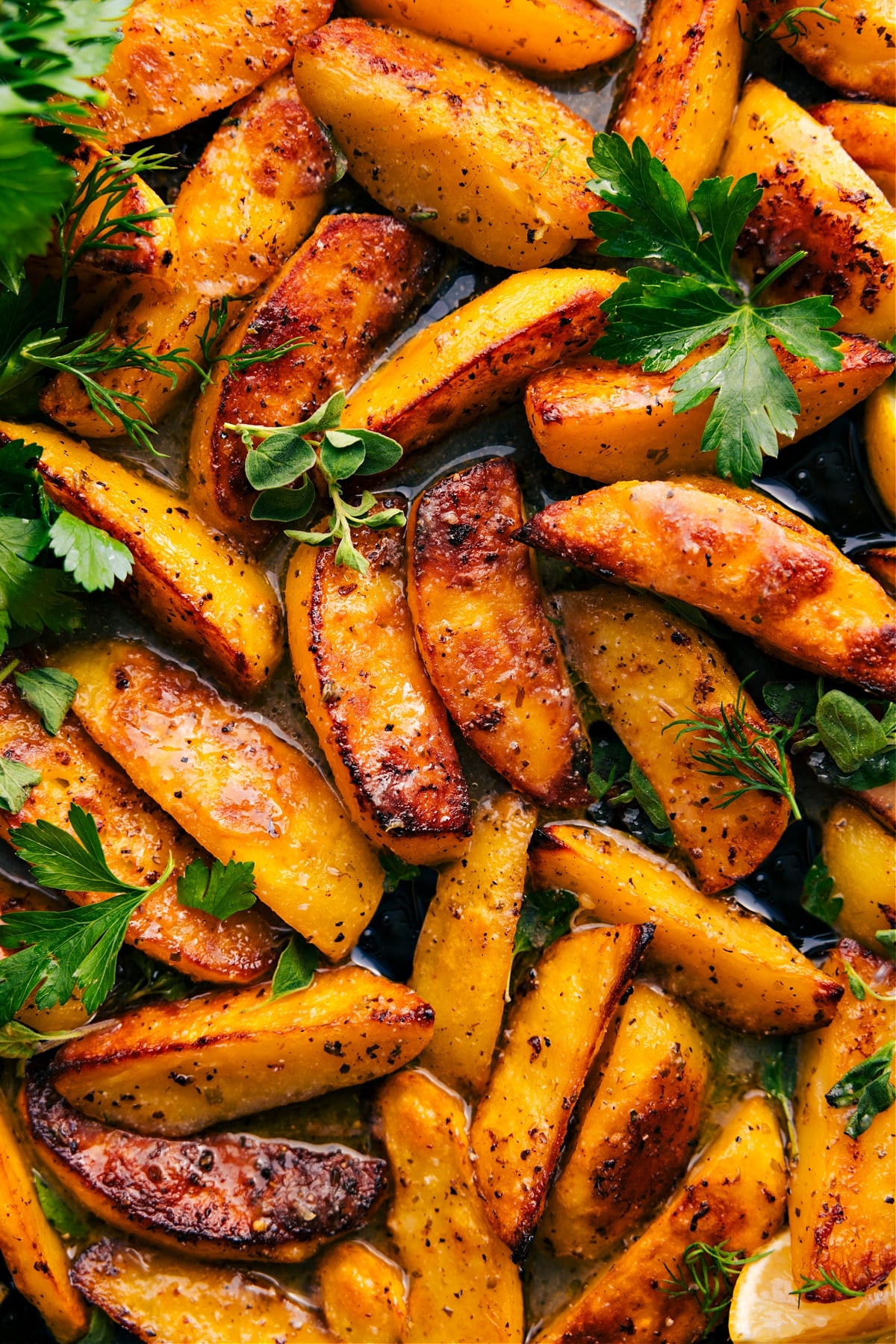 Greek Potatoes Recipe on a tray, finished with fresh parsley and ready to serve.