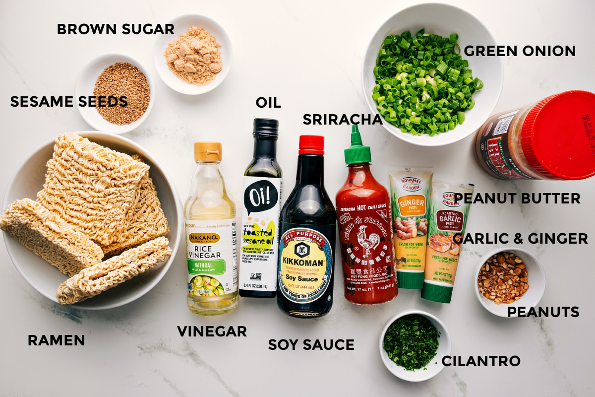 Ingredients In Peanut Butter Ramen All the ingredients in this recipe prepped out for easy assembly including the ramen, sesame seeds, brown sugar, vinegar, oil, soy sauce, sriracha, cilantro, peanut butter, garlic, ginger, peanuts, and green onions.