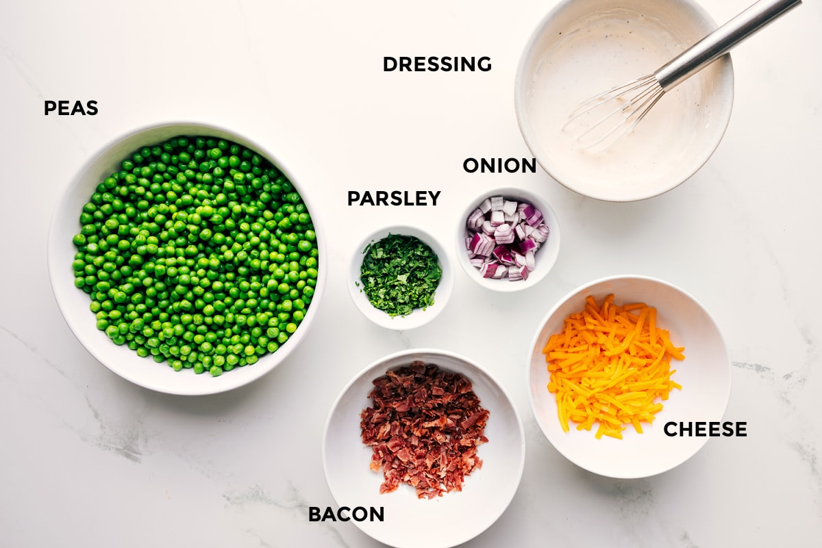 Ingredients In This Pea Salad Recipe All the ingredients in this recipe prepped out for easy assembly including the peas, parsley, onion, cheese, bacon, and dressing.