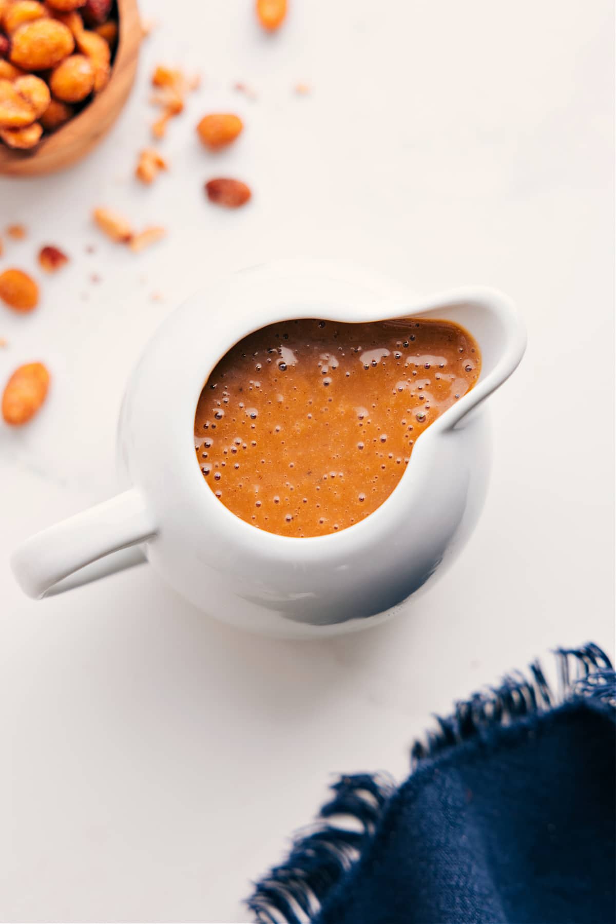 Simple And Flavorful Thai Peanut Dressing Thai peanut dressing in a glass pitcher, ready to pour and serve.