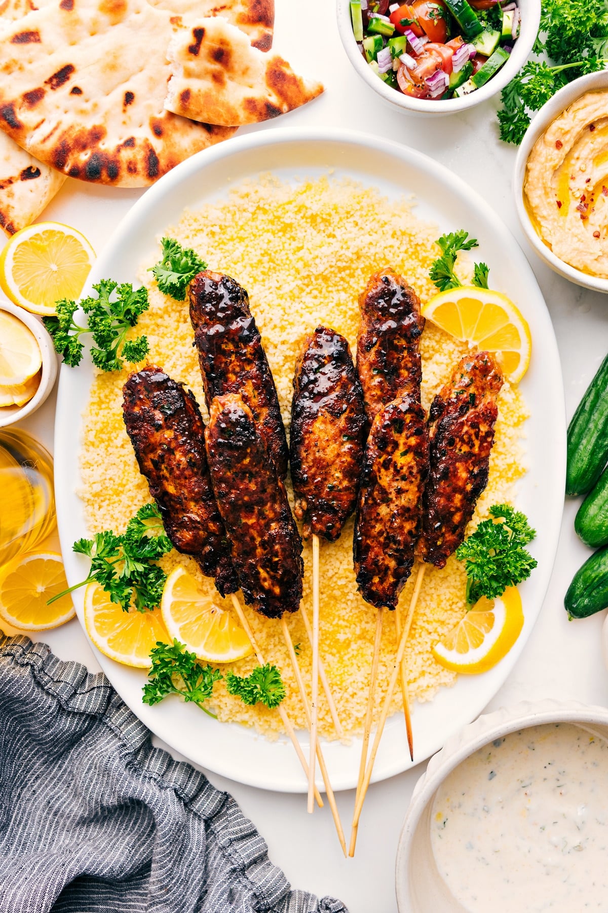 Chicken Kofta Recipe served over couscous with lemon wedges and fresh parsley on the side.