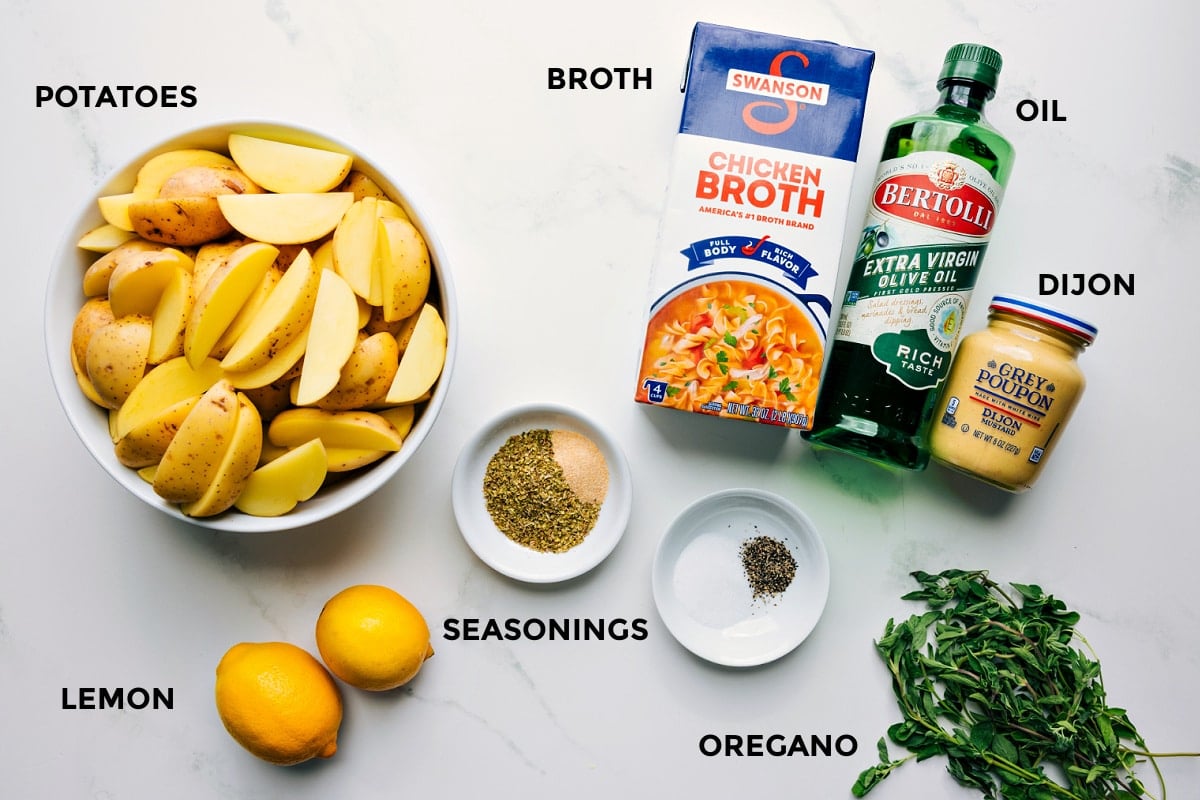 All the ingredients prepped and ready to assemble, including potatoes, lemons, seasonings, broth, oil, and Dijon.