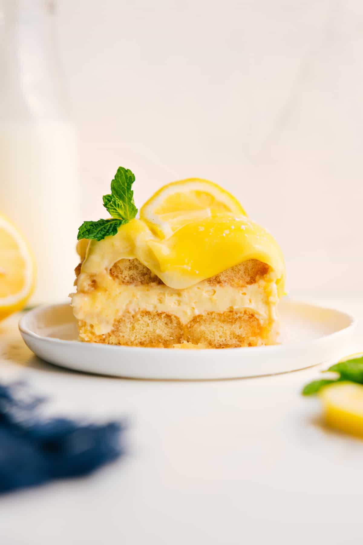Lemon Tiramisu topped with fresh lemon curd, a lemon slice, and mint.