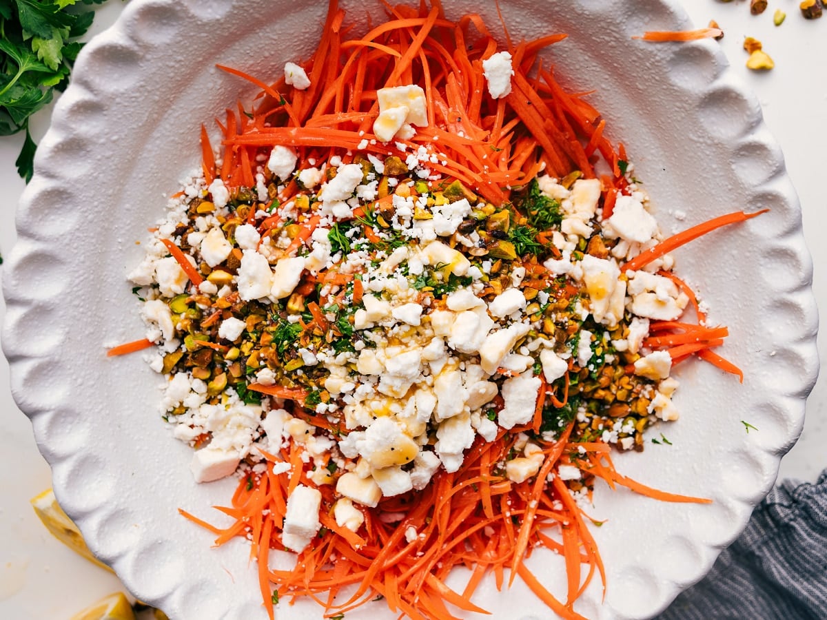 How To Make The Ribbon Carrot Salad Ribbon carrot salad ingredients added to a bowl before tossing together.