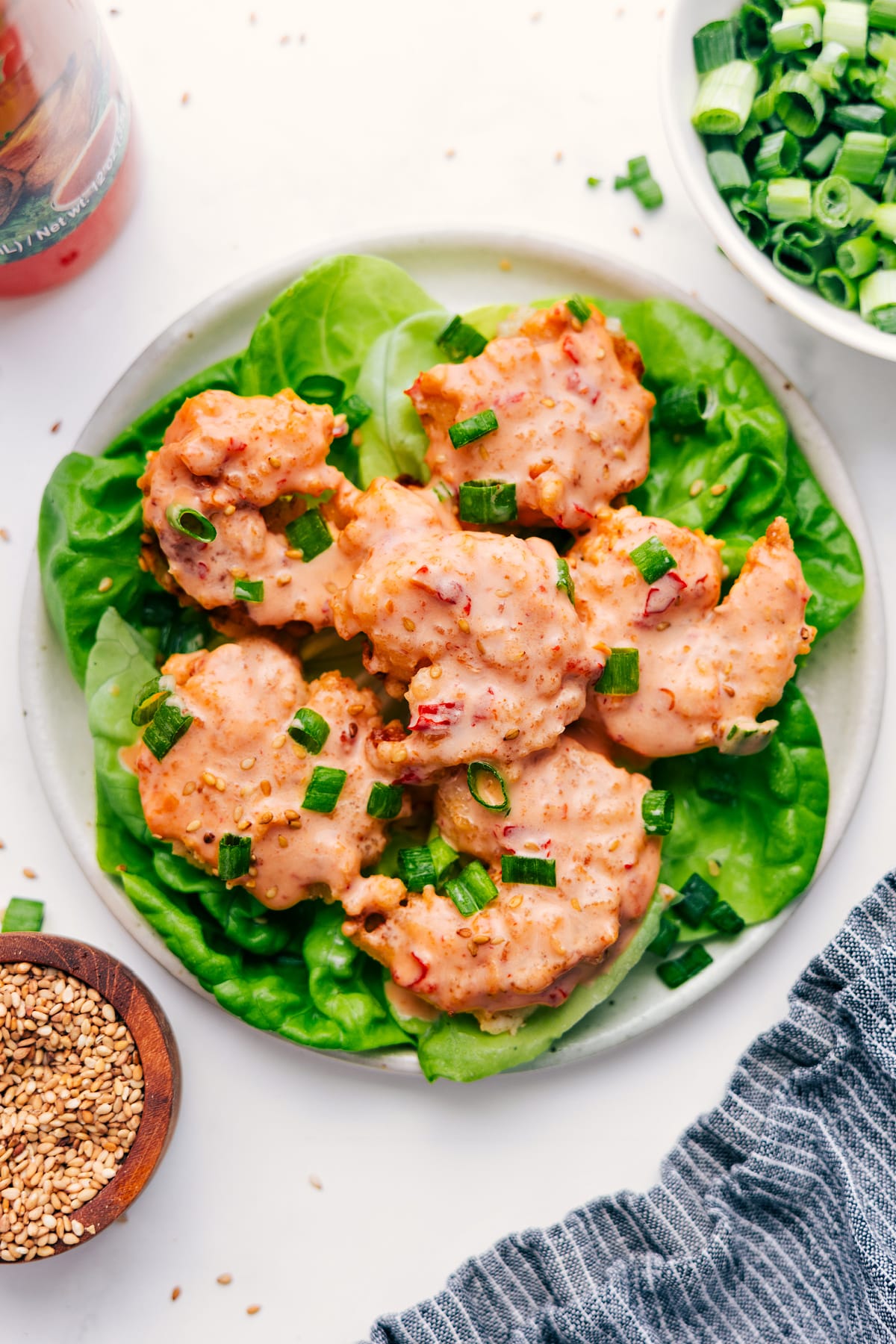 Bang Bang Shrimp served on a bed of lettuce and topped with sliced green onions.