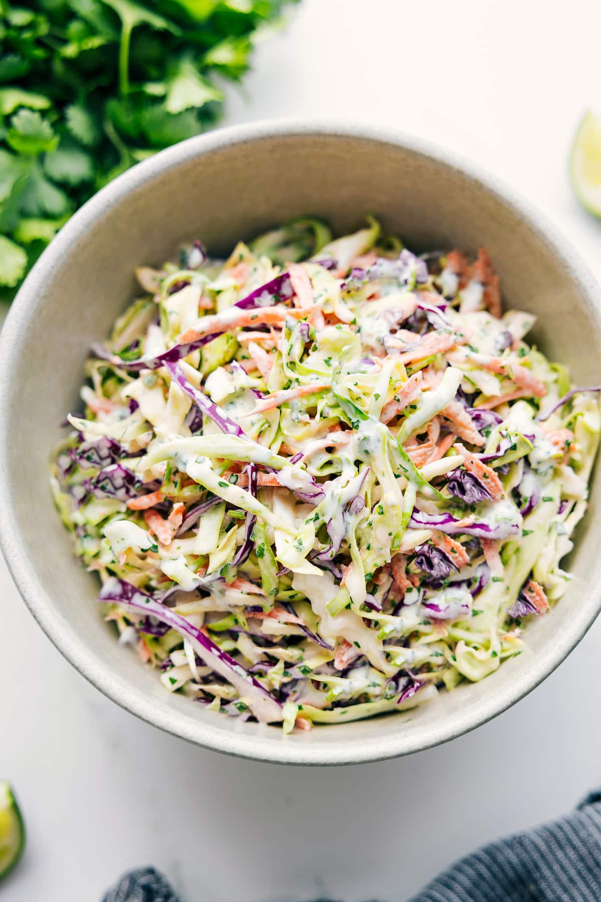 Mexican slaw tossed together in a bowl with dressing evenly coating the cabbage.