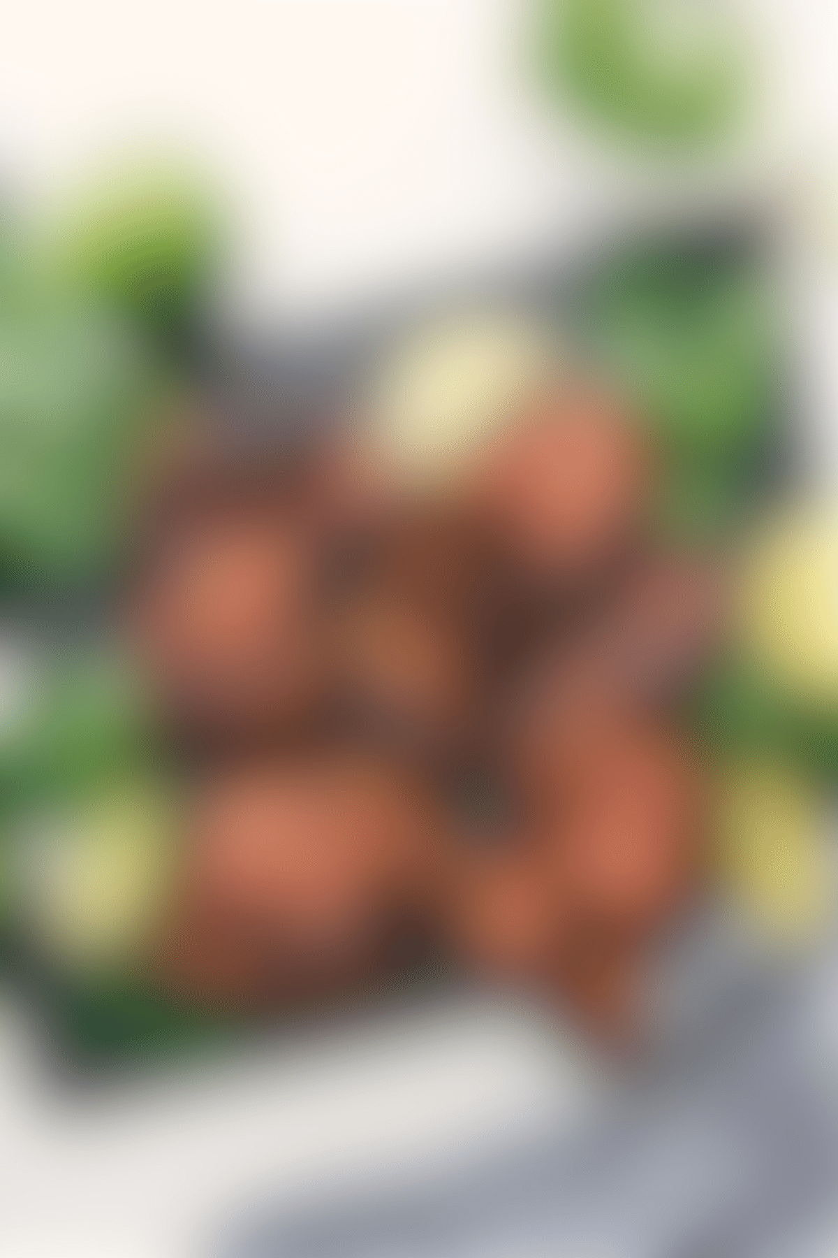 Sweet Green baked chicken thighs on the cutting board with fresh cilantro and limes on the side.