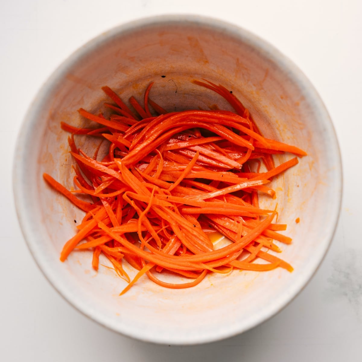 Carrots Tossed With Dressing The carrots being shredded and marinated in the dressing for this veggie sandwich.