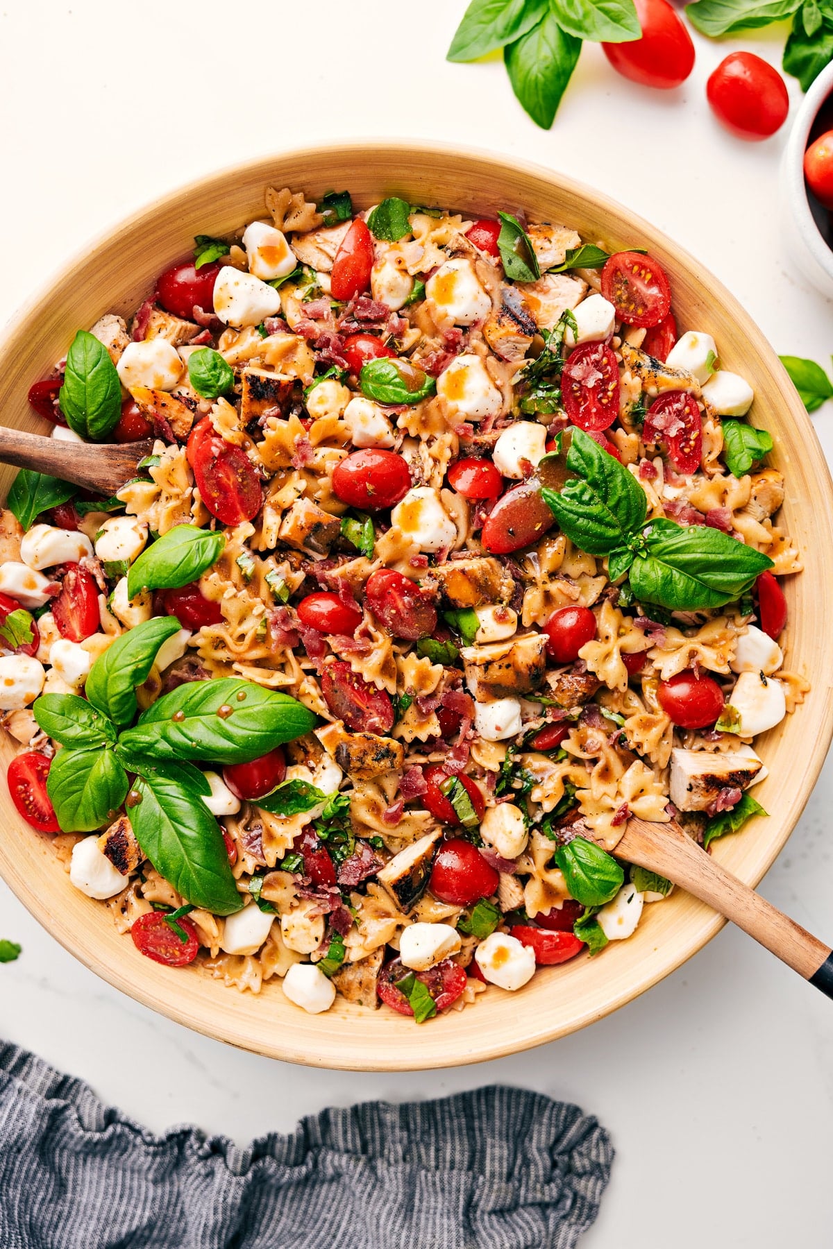 Easy And Delicious Caprese Pasta Salad Ready Caprese Pasta Salad in a large bowl with dressing drizzled over the top, ready to enjoy.