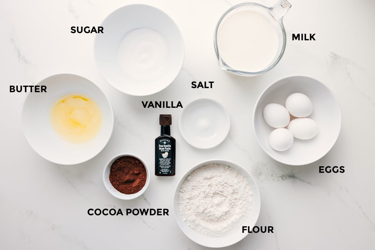 Ingredients To Make Chocolate Crepes All the ingredients for this recipe prepped and ready for easy assembly, including butter, sugar, cocoa powder, vanilla, salt, flour, eggs, and milk.